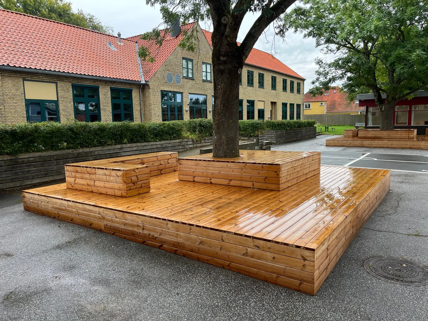 Nyolieret termofyr på siddebænke og trædæk, orangebrun farve, skolegård i Melby