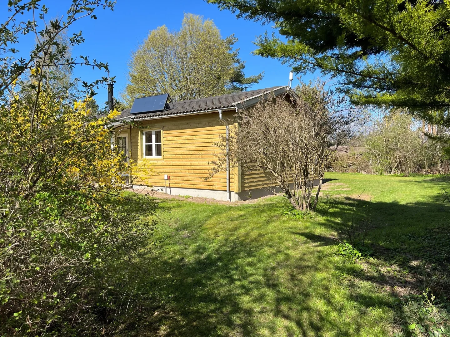 Efterisoleret sommerhus med ny lys facadebeklædning i træ, Melby