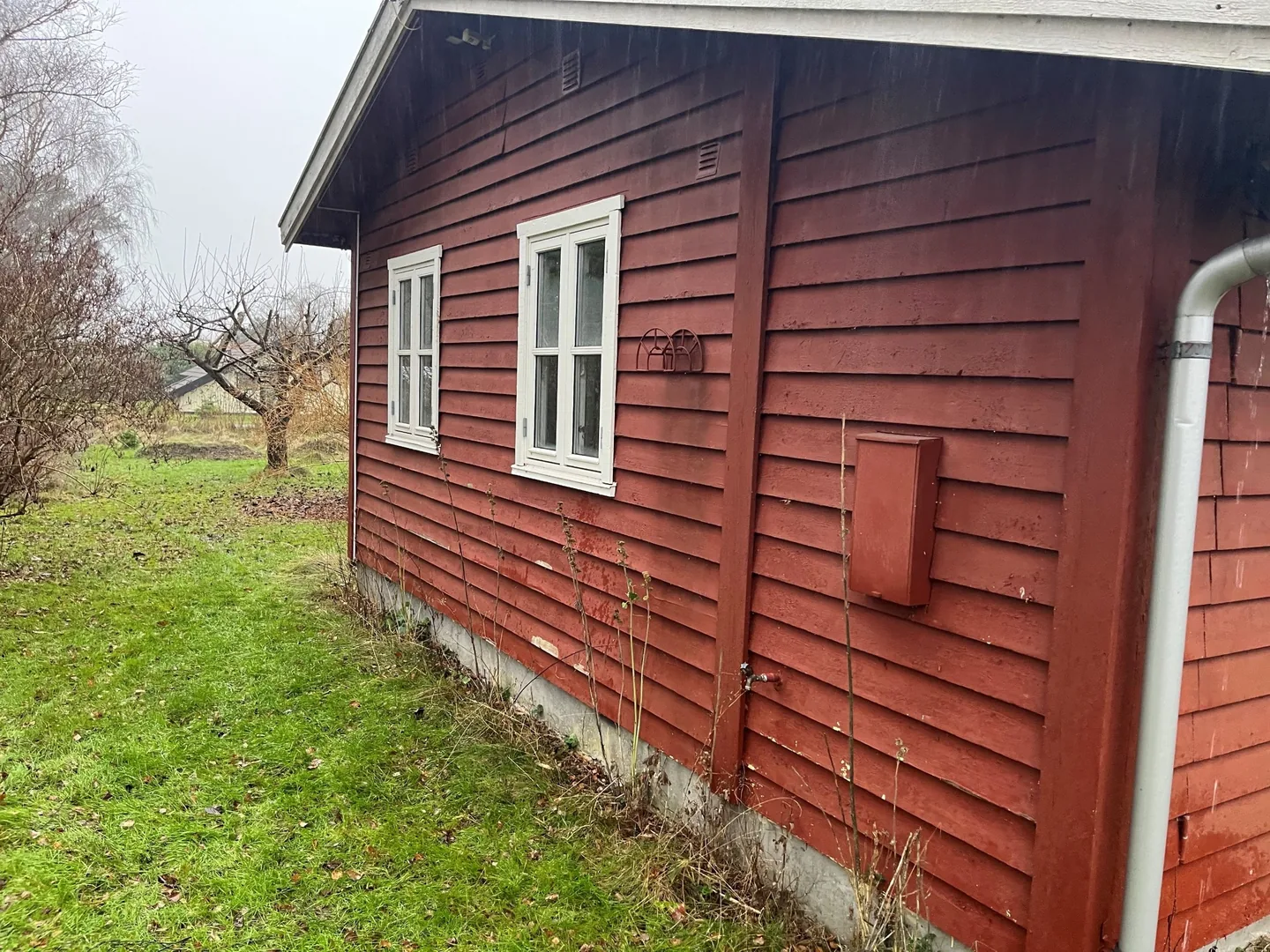 Gavl på rødmalet sommerhus før renovering af facaden, Melby