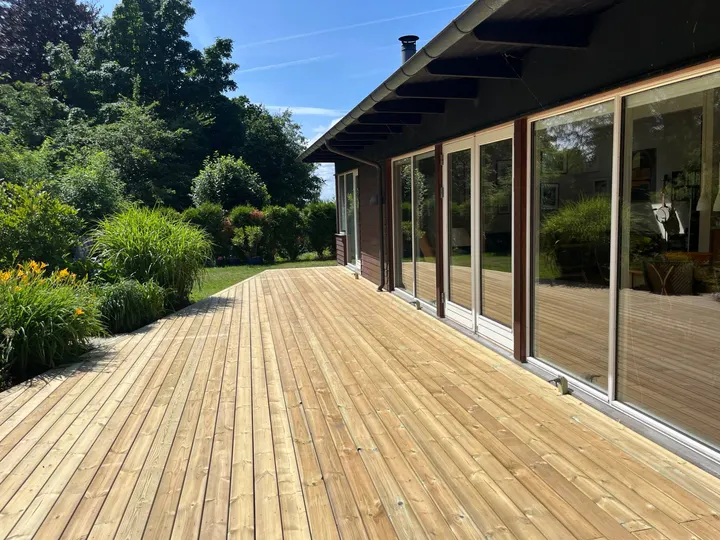 Ny træterrasse i trykimprægneret træ ved et hus med store glaspartier i Hundested.